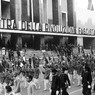 Gruppo del dopolavoro Fiat sfila, con bandiere e insegne, davanti all'ingresso della Mostra della Rivoluzione Fascista