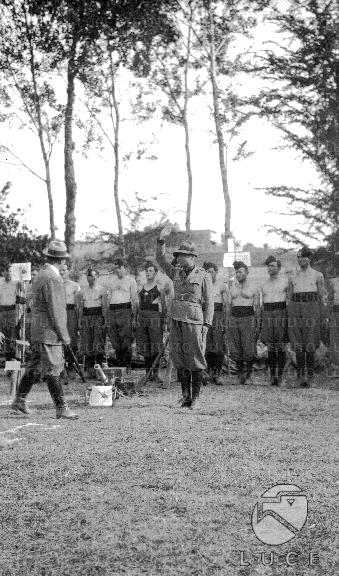Un milite fa il saluto fascista mentre Mussolini passa in rivista le ...