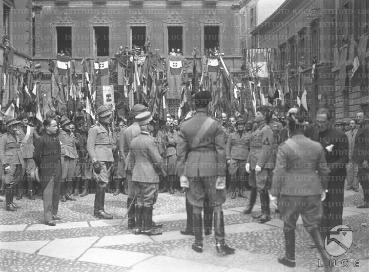 Mussolini si intrattiene con un gruppo di autorità in piazza Belgioioso ...