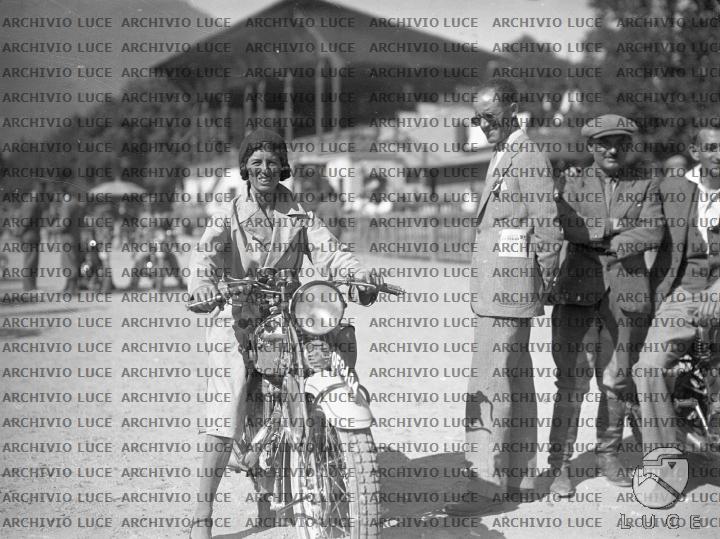 I Preparativi Per La Partenza Alla Volta Della Colchide Una donna partecipante alla Sei giorni motociclistica colta, durante i