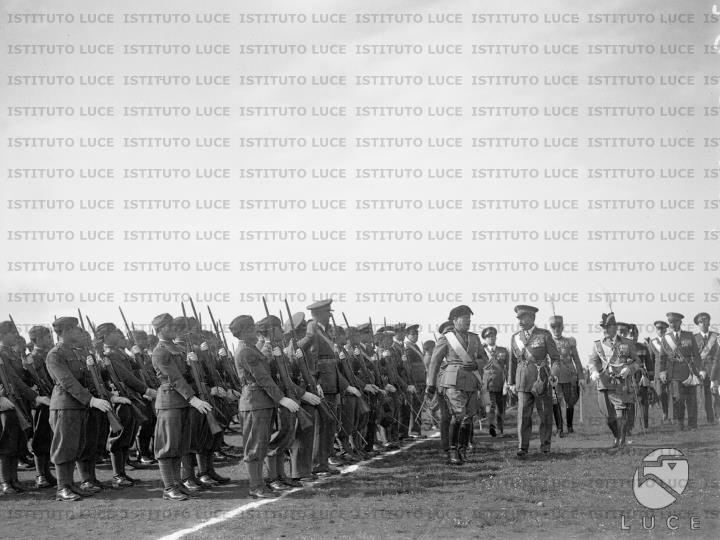 Mussolini accompagnato da numerose autorità militari, passa in rassegna ...