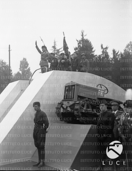 Mussolini, con Starace e autorità, su un podio appoggiato su una ...