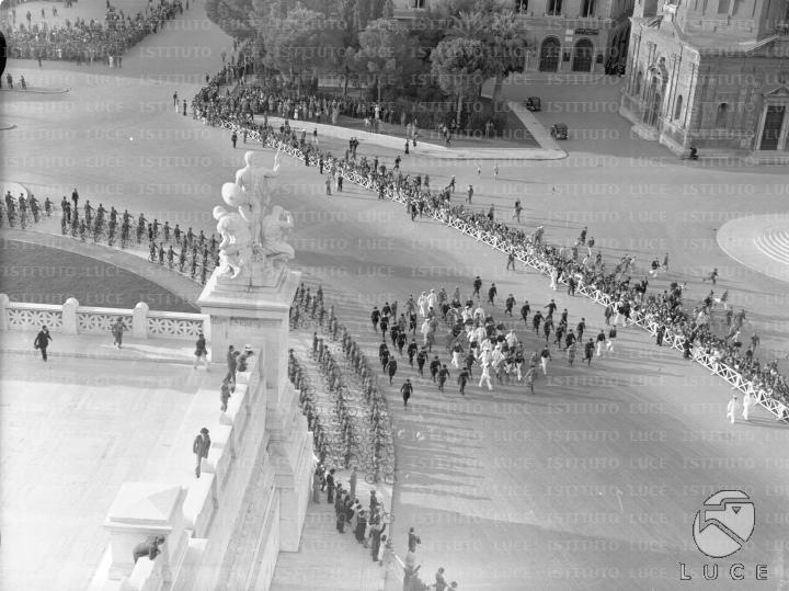 Mussolini ed un folto gruppo di gerarchi sfilano in piazza Venezia ...