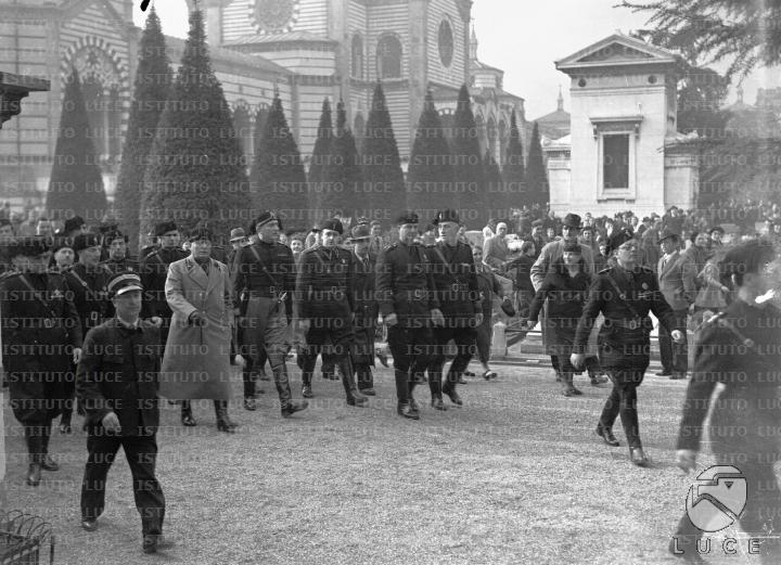 Mussolini, accompagnato da Starace e da un folto gruppo di gerarchi ...