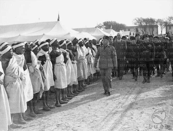 Mussolini passa in rassegna un gruppo di comparse africane in costume ...