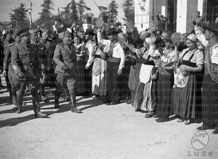 Mussolini, accompagnato da Italo Balbo e da autorità, attraversa la ...