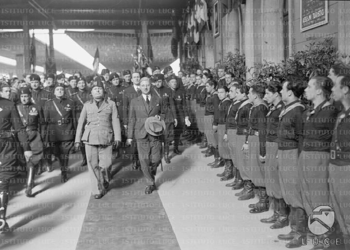Mussolini e il cancelliere austriaco Schuschnigg, seguiti da un folto ...