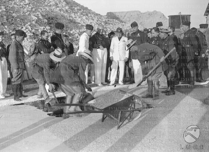 Mussolini, accompagnato da un gruppo di autorità, visita una miniera di ...