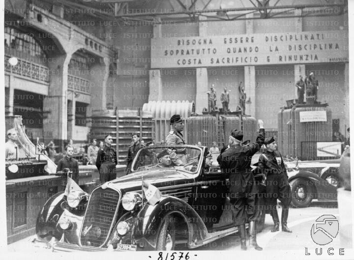 L'auto scoperta su cui viaggia Mussolini transita all'interno di uno ...