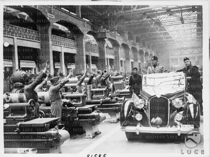 L'auto scoperta su cui viaggia Mussolini transita all'interno di uno ...