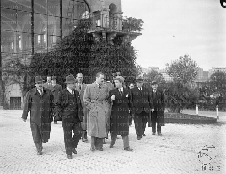 Bruno Mussolini, accompagnato da un gruppo di personalità, cammina ...