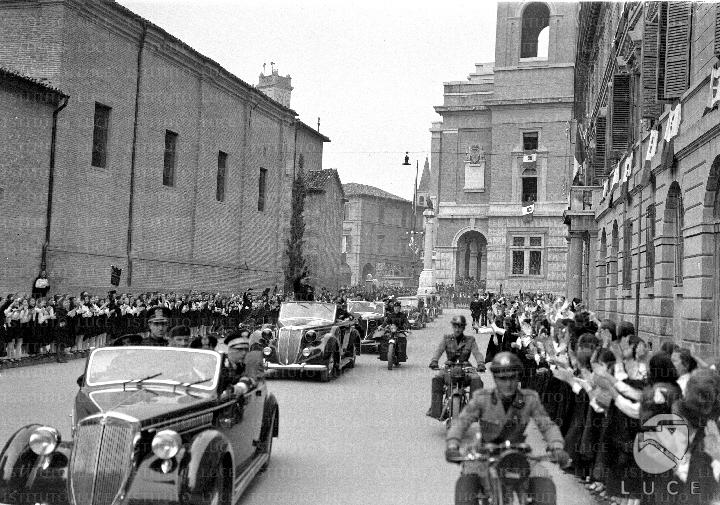 Il corteo di automobili, al seguito di Benito Mussolini, percorre una ...