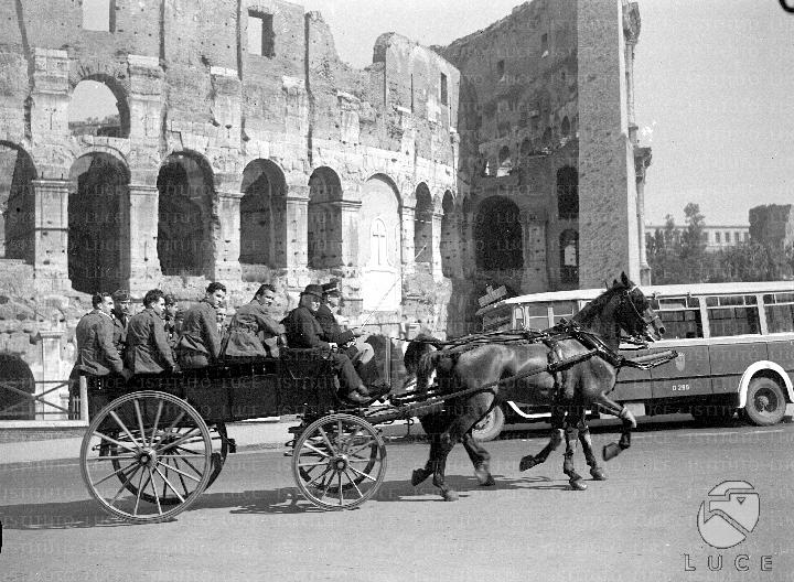 La carrozza a cavalli, con a bordo i mutilati di guerra in visita a Roma, percorre via Celio Vibenna