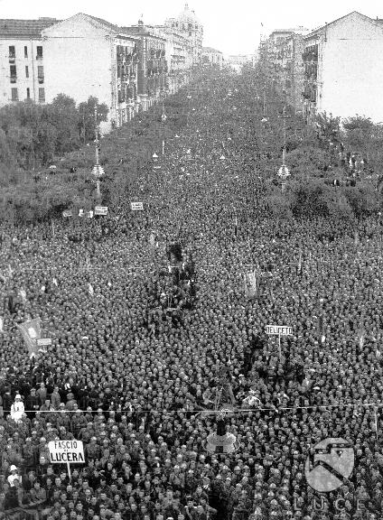 Una folla immensa assiste al discorso di Mussolini lungo i viali di una ...