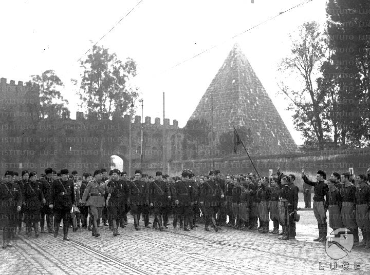Mussolini, accompagnato da un folto gruppo di gerarchi, percorre via ...