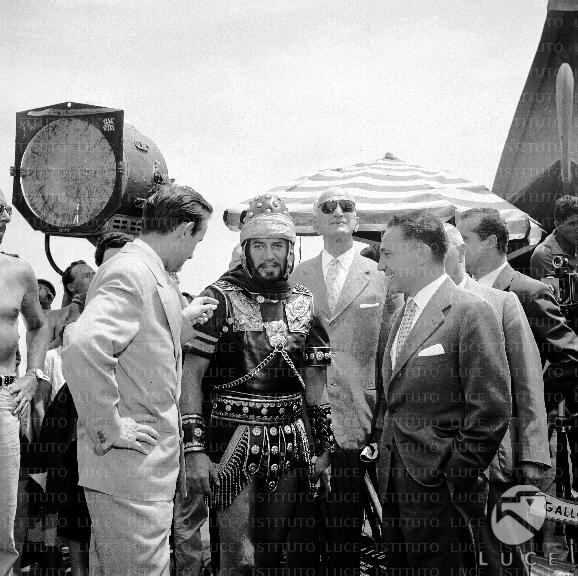 Ferrari Aggradi con attori in costume sul set di un film a Cinecittà