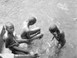 Tre bambini indigeni fanno il bagno in un fiume