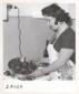 Una donna mostra una padella di carciofi cucinati