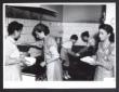 Cinque donne sono impegnate in cucina. Due di loro ...