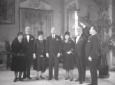 Mussolini posa fra due signore, insieme ad altri u ...