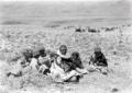Un indigeno seduto sulla paglia tra bimbi indigeni