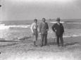 Tre uomini in posa sulla spiaggia