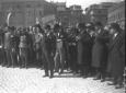 Circondato da autorit, Mussolini, con una bandier ...
