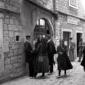 persone sostano davanti all'ingresso di un locale, ...