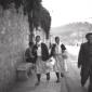 Due donne e un uomo in abiti tradizionali camminan ...