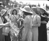 Ragazze con cappelli di paglia si passano il bicch ...