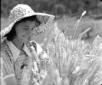 Una ragazza con il cappello di paglia sorride tra  ...