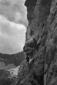 Un alpinista risale una parete rocciosa; ...