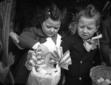 Due bambini sorreggono i cestini ornati  ...