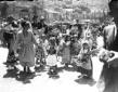 Gruppo di bambine in abiti tradizionali trasporta  ...