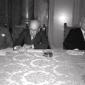 Clement Attlee legge un foglio sul tavolo dei rela ...