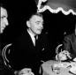 Clark Gable fuma una sigaretta seduto a tavola