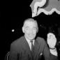 Clark Gable fuma una sigaretta seduto a tavola