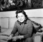 Anna Magnani fuma una sigaretta seduta sul divano  ...