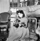 Anna Magnani suona la chitarra seduta davanti ad u ...