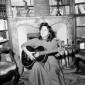 Anna Magnani suona la chitarra seduta davanti ad u ...