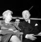 Giuseppe Pella parla con una signora mentre siede  ...