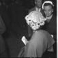Una donna (di spalle) mostra il suo cappellino con ...