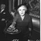 Lina Merlin, con cappellino in testa, porge un vas ...