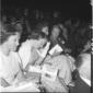 Ragazze elegantemente vestite sedute in platea; pi ...