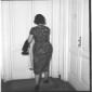 Una donna di spalle vicino a una porta - totale