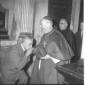 Un uomo si inginocchia e bacia la mano al cardinal ...