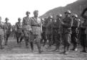 Mussolini passa in rassegna le truppe seguito da a ...