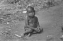 Un bimbo piccolo sudanese siede a terra